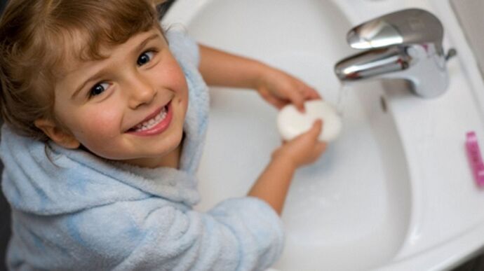 The child washes his hands with soap to prevent worms.